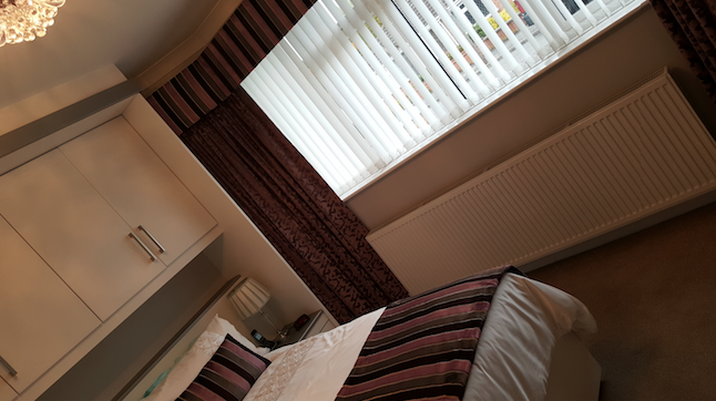 bedroom with verical blinds and curtains